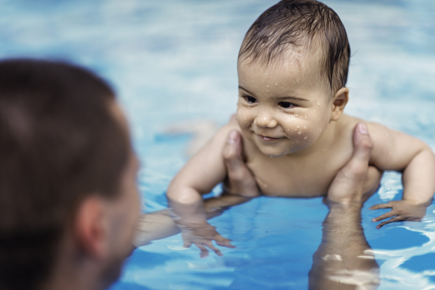baby learning how to swim in a pool